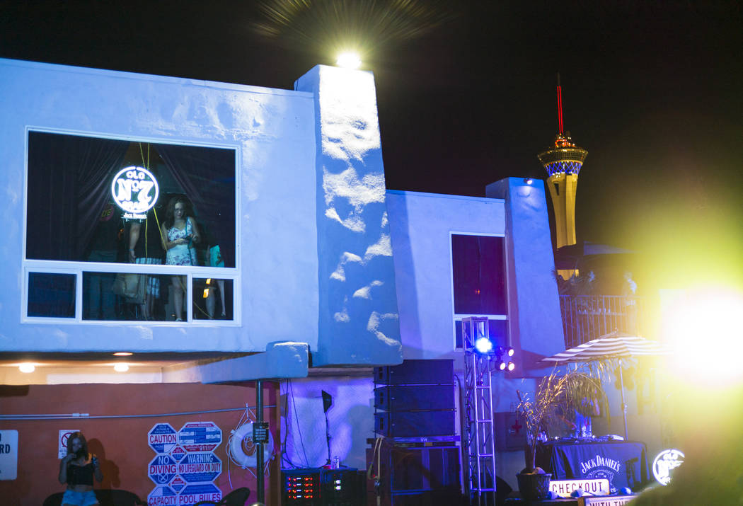 Attendees look out from the White Rabbit speakeasy saloon, left, during the Jack Daniel's House ...