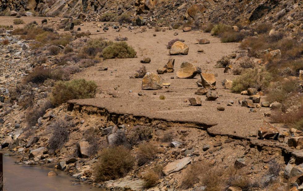 Rocks are scattered on an old access road along a small stream of fresh water coming from the e ...