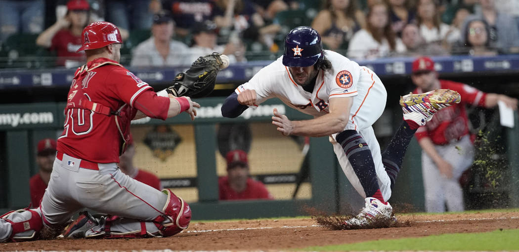 Houston Astros' Jake Marisnick, right, collides Los Angeles Angels catcher Jonathan Lucroy (20) ...