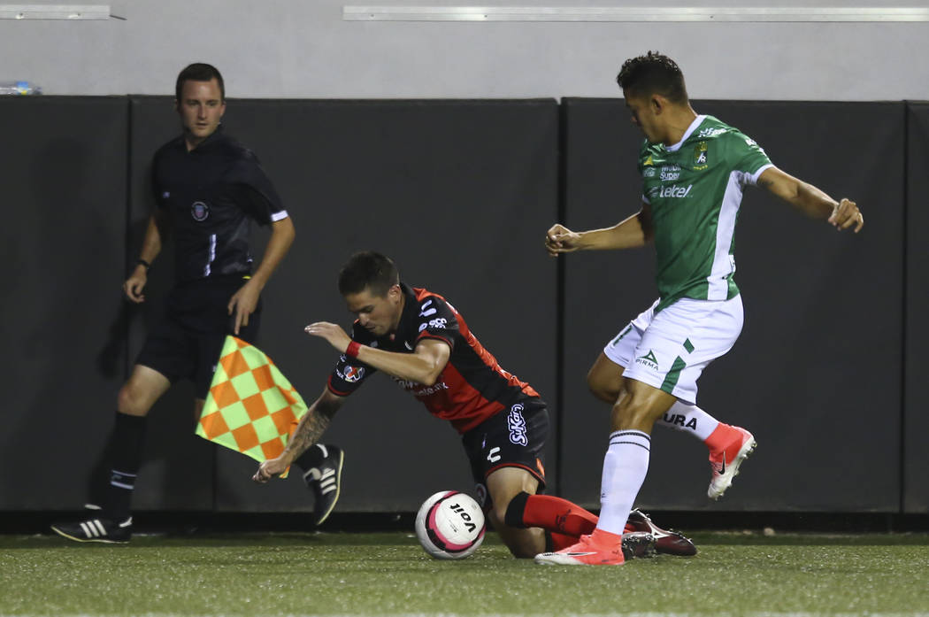 Tijuana's Damian Perez, left, is tripped up by Leon's Andres Andrade during an exhibition socc ...