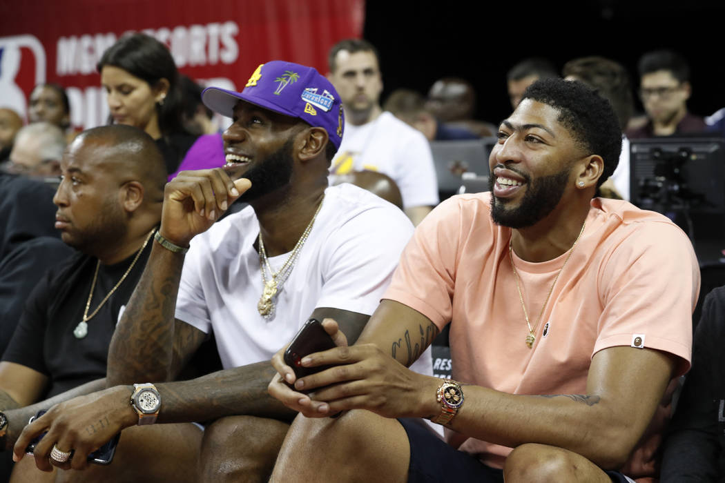 Los Angeles Laker players LeBron James, center, and Anthony Davis, right, take in an NBA summer ...