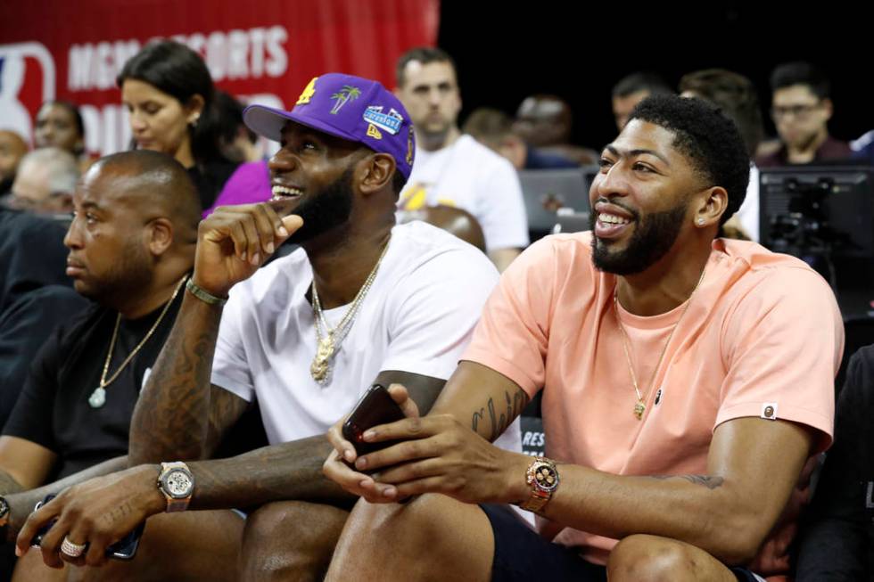 Los Angeles Laker players LeBron James, center, and Anthony Davis, right, take in an NBA summer ...