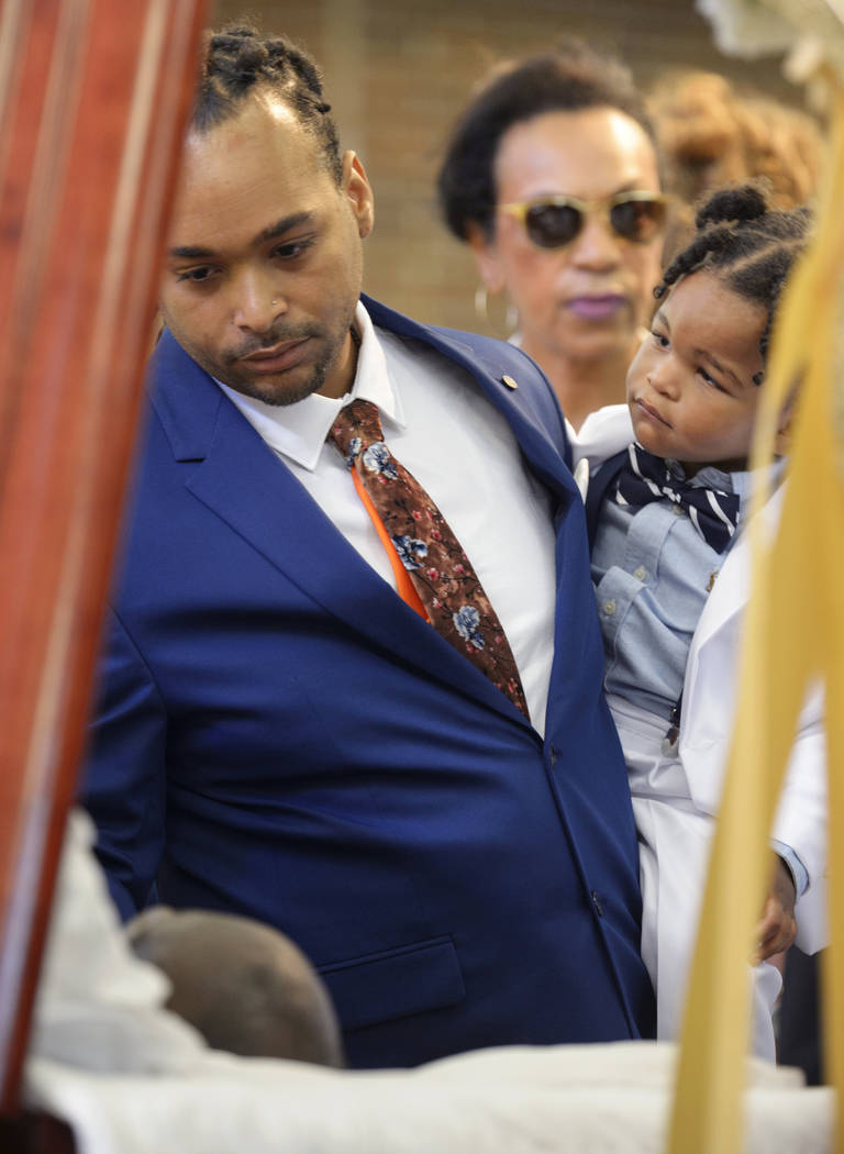 Don Bartholomew Jr., with son Lyric, looks at the body of Dave Bartholomew during the viewing a ...