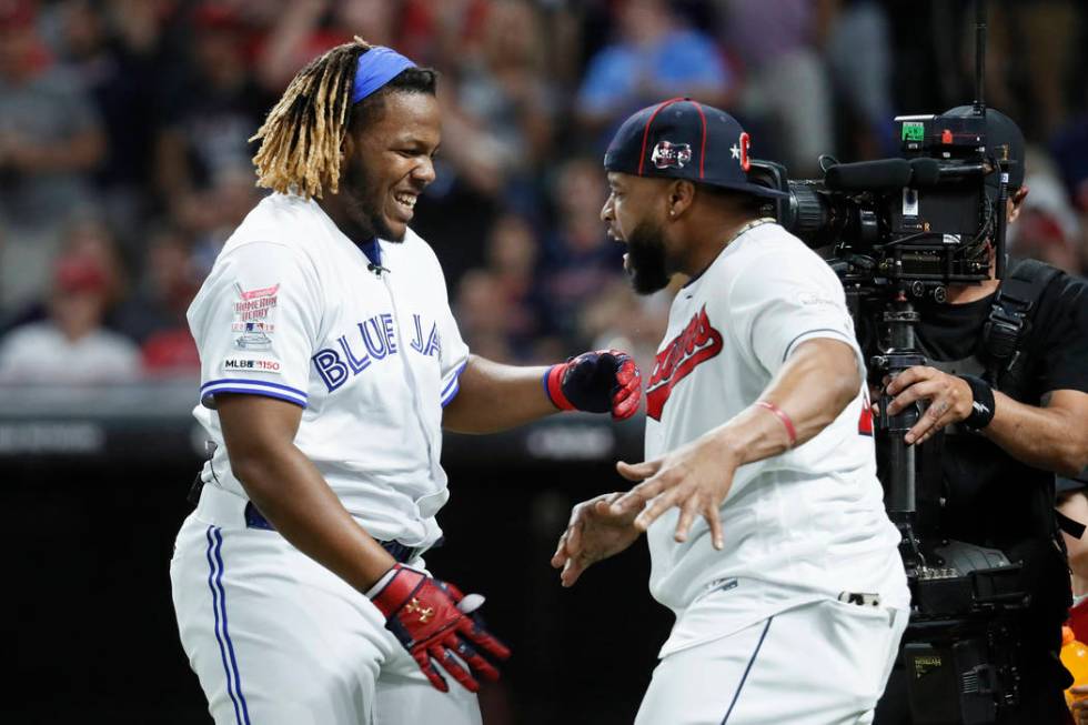 Vladimir Guerrero Jr., left, of the Toronto Blue Jays, is greeted by Carlos Santana, of the Cle ...