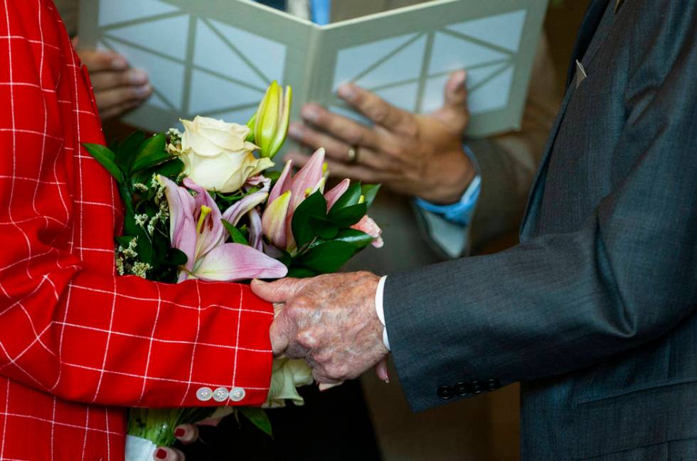 Gail and Donna Andress hold hands during a renewal of vows ceremony celebrating their 75th wedd ...