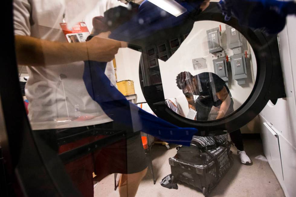 UNLV students Devin James, left, and Wesley Wharton work on organizing clothes for NBA teams in ...