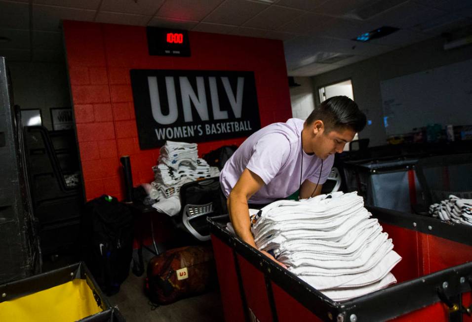 UNLV student Misael Arambula organizes towels as basketball games continue in the Thomas & ...