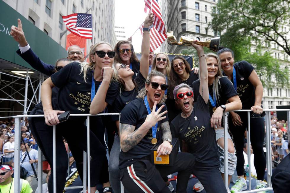 Megan Rapinoe holds the Women's World Cup trophy as the U.S. women's soccer team is celebrated ...