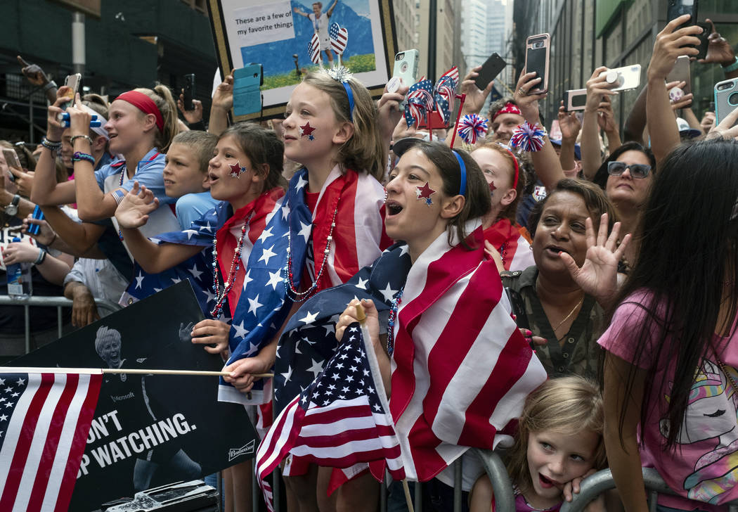 Fans celebrates as members of the the U.S. women's soccer team pass by during a ticker tape par ...
