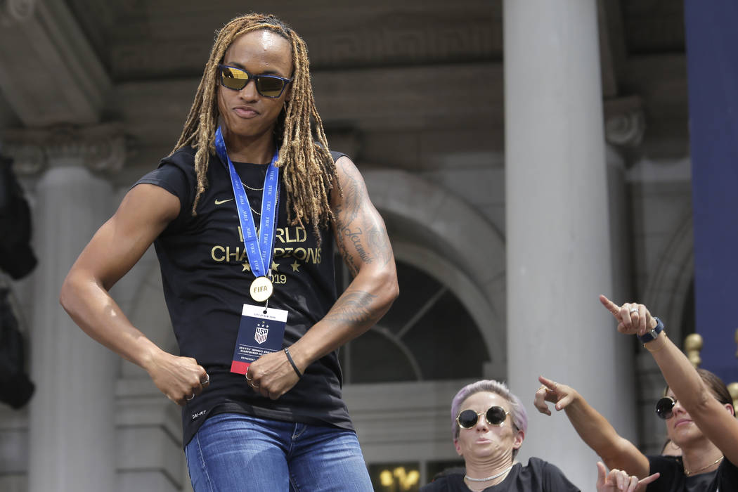 The U.S. women's soccer team member Jessica McDonald flexes during a celebration at City Hall a ...