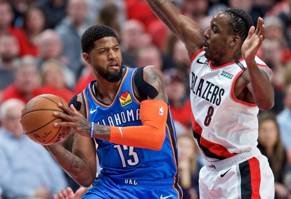 In this April 16, 2019, file photo, Oklahoma City Thunder forward Paul George, left, looks to p ...