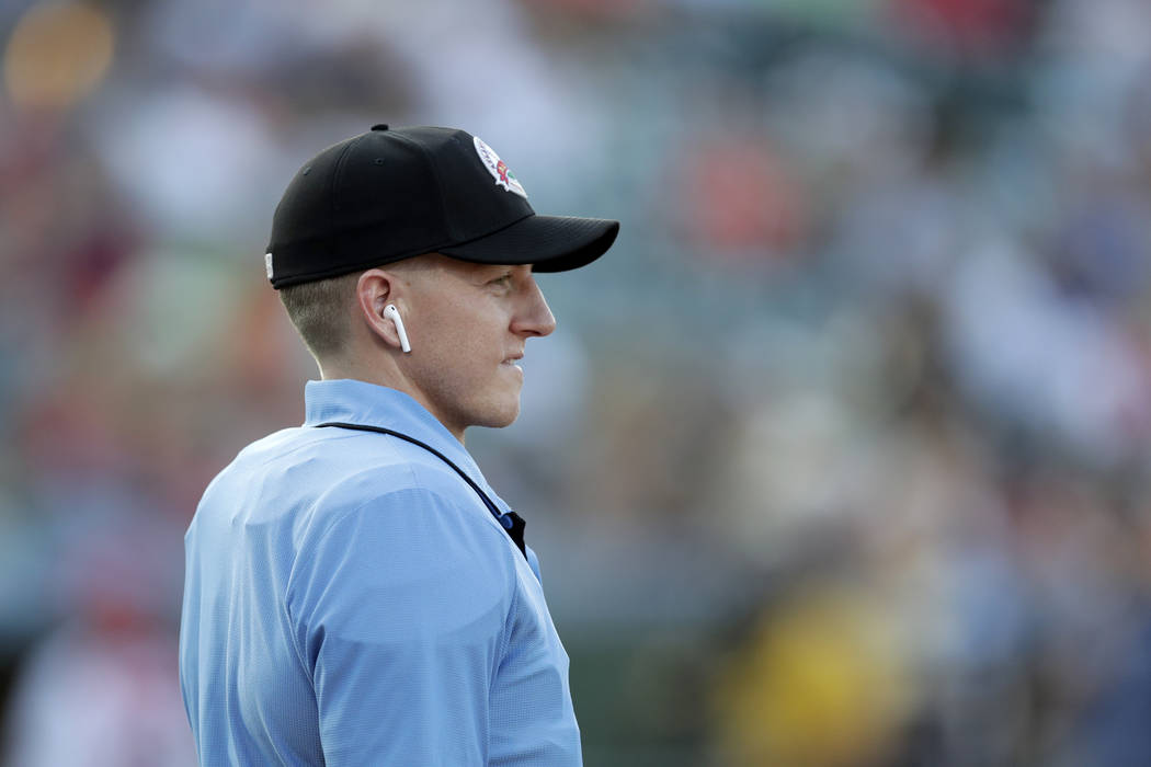 Home plate umpire Brian deBrauwere looks on while wearing an earpiece connected to a ball and s ...