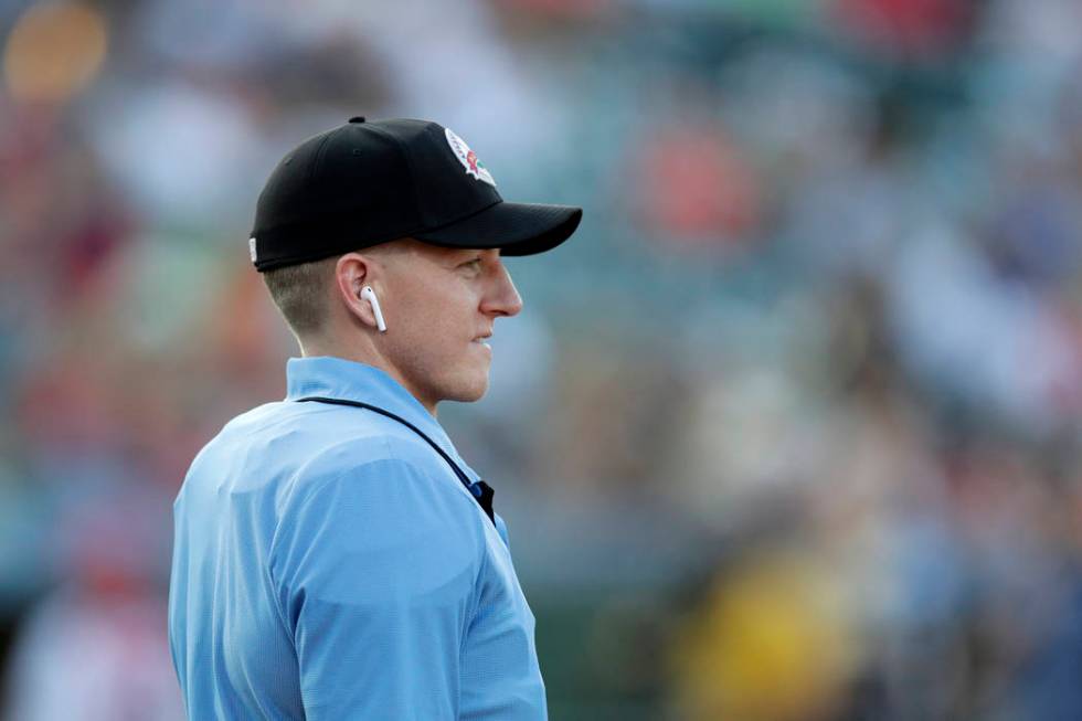 Home plate umpire Brian deBrauwere looks on while wearing an earpiece connected to a ball and s ...