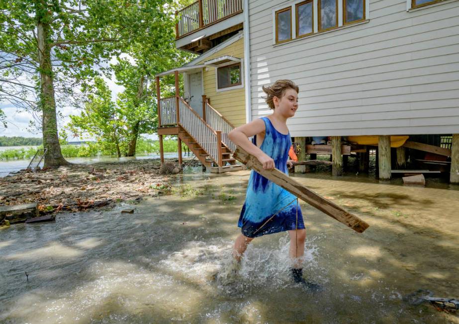 Tallulah Campbell, 8, clears out driftwood and other debris in preparation of Tropical Storm Ba ...