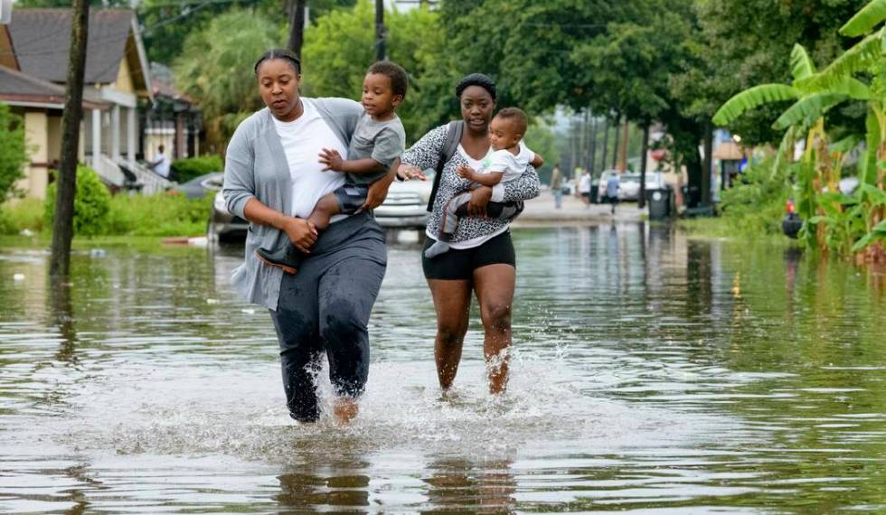 Jalana Furlough carries her son Drew Furlough as Terrian Jones carries Chance Furlough on Belfa ...