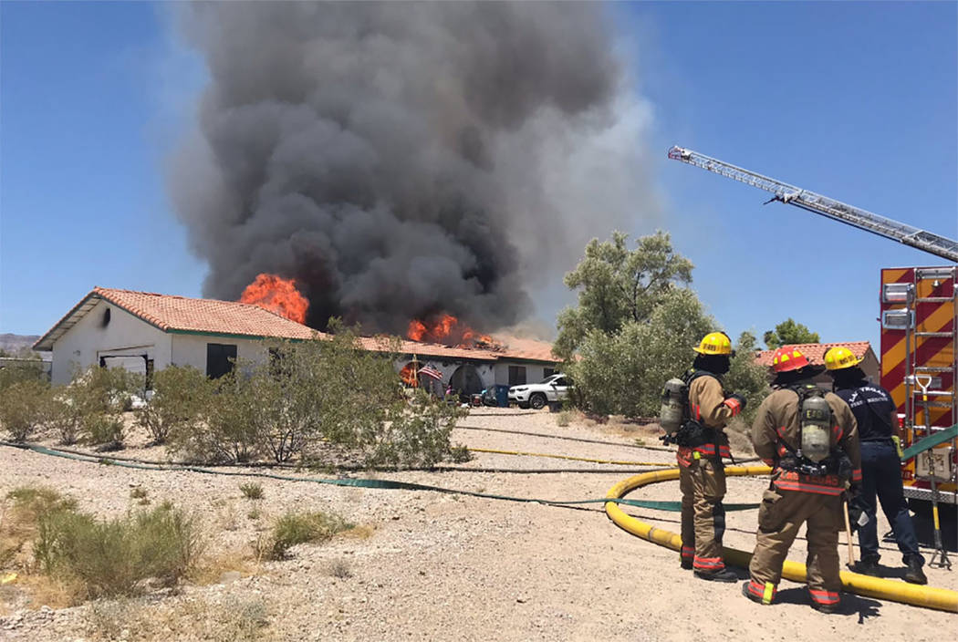 Crews battle a house fire Thursday, July 11, 2019, on the 5300 block of North Fort Apache Road ...