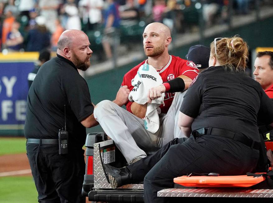 Los Angeles Angels' Jonathan Lucroy, center, is carted off the field after colliding with Houst ...