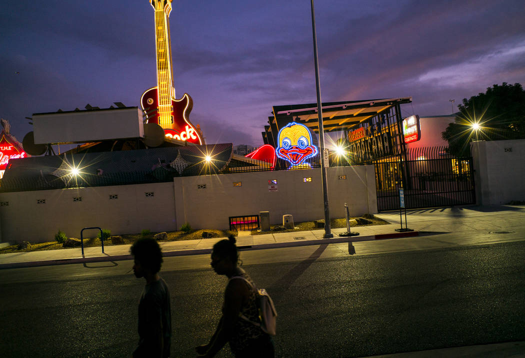 People walk by the recently restored Ugly Duckling sign at the Neon Museum in downtown Las Vega ...