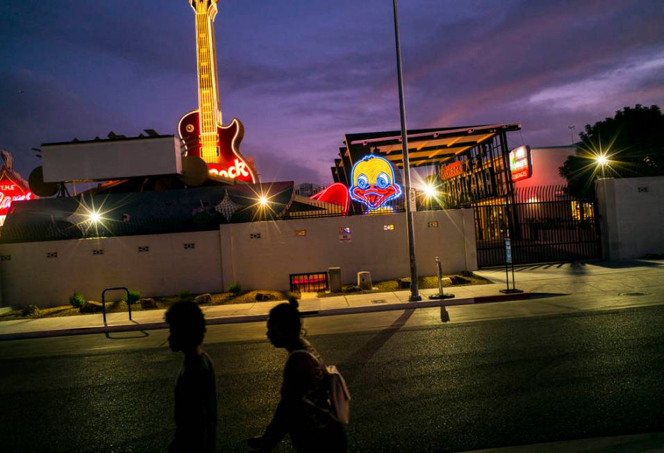 People walk by the recently restored Ugly Duckling sign at the Neon Museum in downtown Las Vega ...