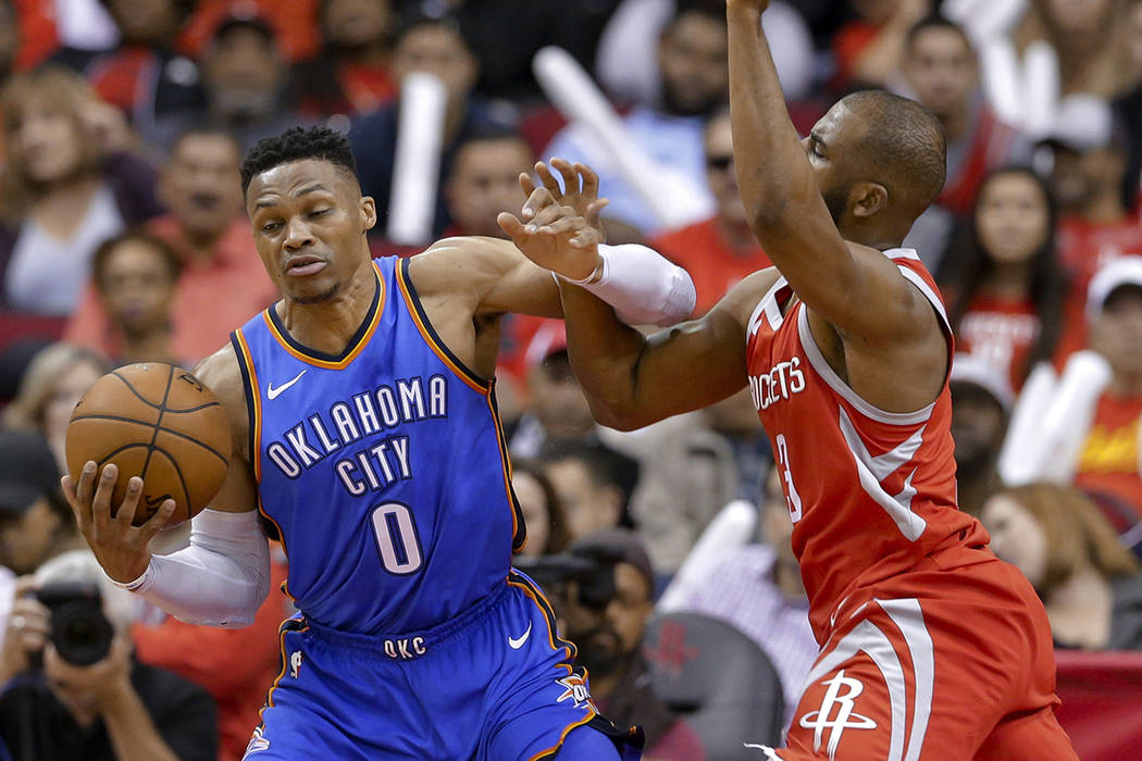 Oklahoma City Thunder guard Russell Westbrook (0) is fouled by Houston Rockets guard Chris Paul ...