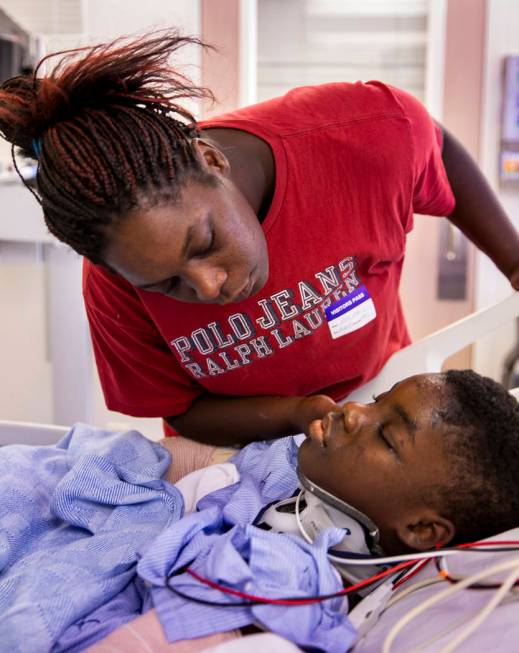 Thylicia McKnight, above, attempts to wake her son Lennie Modica, 9, who is in recovery in the ...