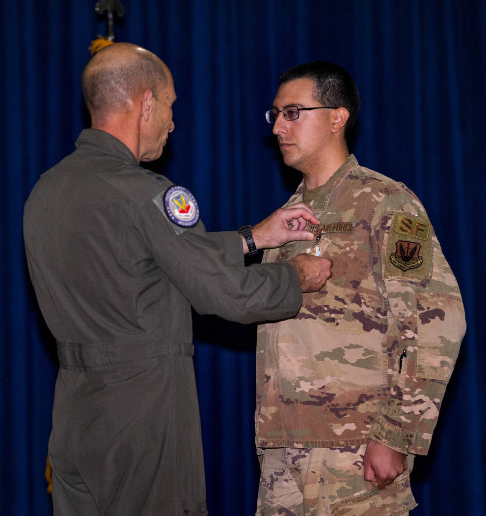 Gen. Mike Holmes, Commander of Air Combat Command, left, presents Staff Sgt. Kenneth DeLongcham ...