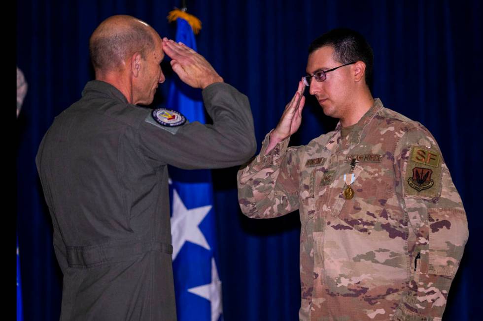 Gen. Mike Holmes, Commander of Air Combat Command, left, salutes with Staff Sgt. Kenneth DeLong ...