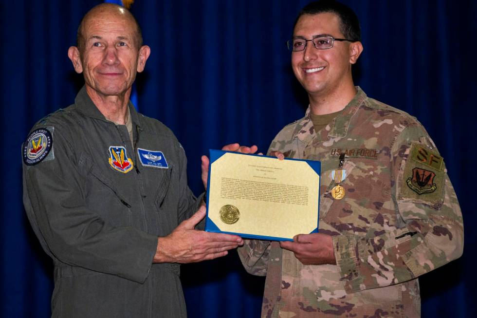 Gen. Mike Holmes, Commander of Air Combat Command, left, poses for a photo with Staff Sgt. Kenn ...