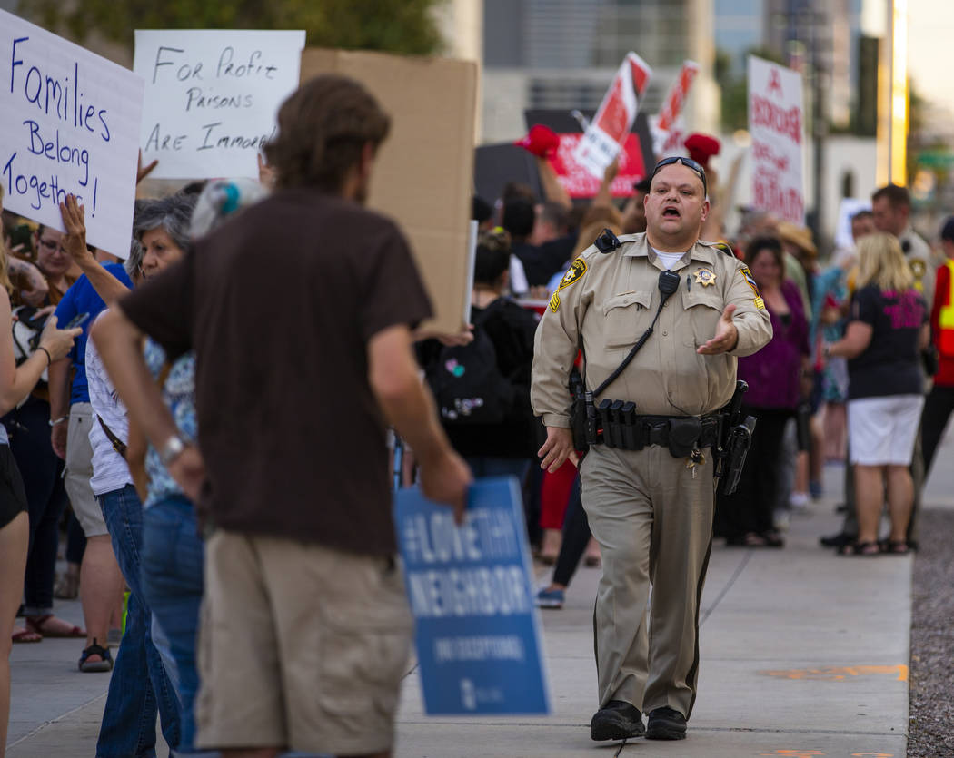 A Metropolitan Police officer urges attendees to keep the sidewalk clear during Lights for Libe ...