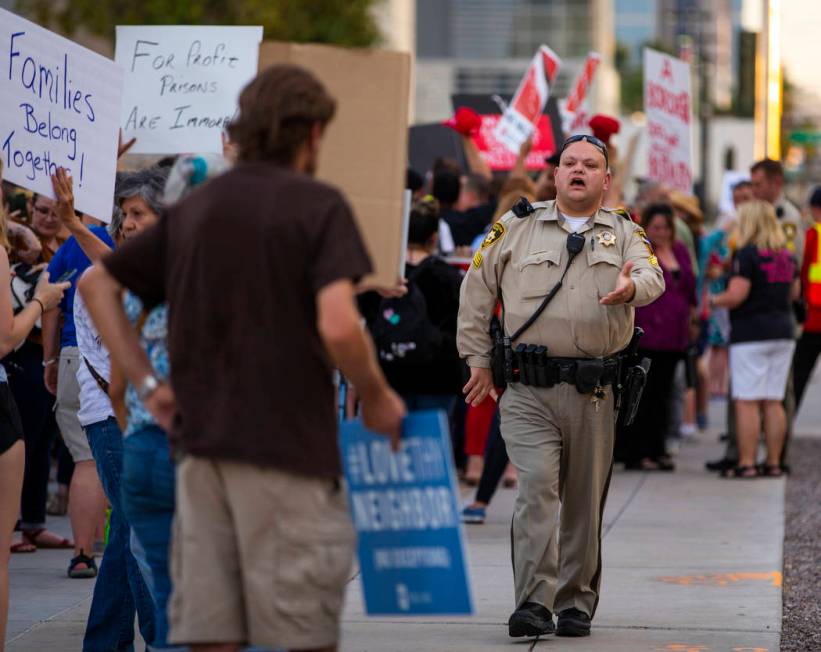 A Metropolitan Police officer urges attendees to keep the sidewalk clear during Lights for Libe ...