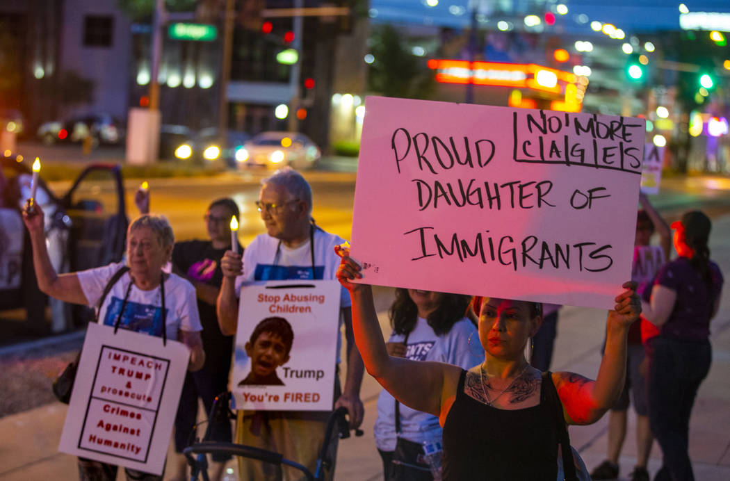 Activist Jessica Vasquez holds a sign for her parents during Lights for Liberty: A Vigil to End ...