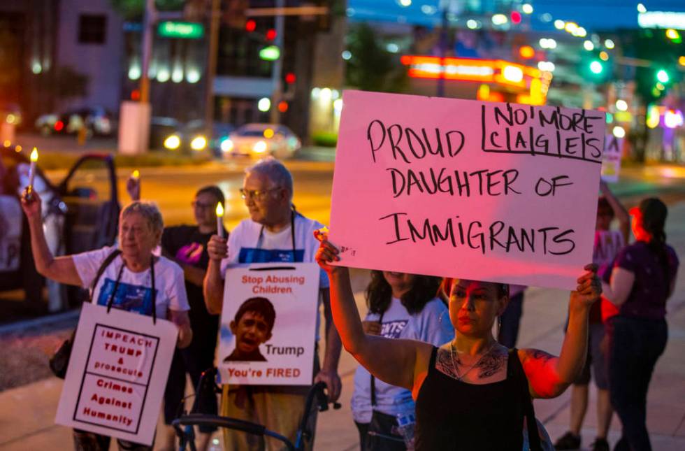 Activist Jessica Vasquez holds a sign for her parents during Lights for Liberty: A Vigil to End ...