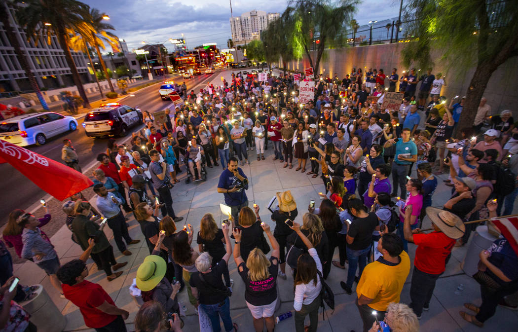 Advocates, activists and impacted persons hold lit candles and yell protest chants during Light ...