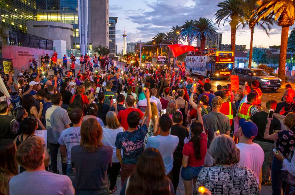 Advocates, activists and impacted persons hold lit candles and yell protest chants during Light ...