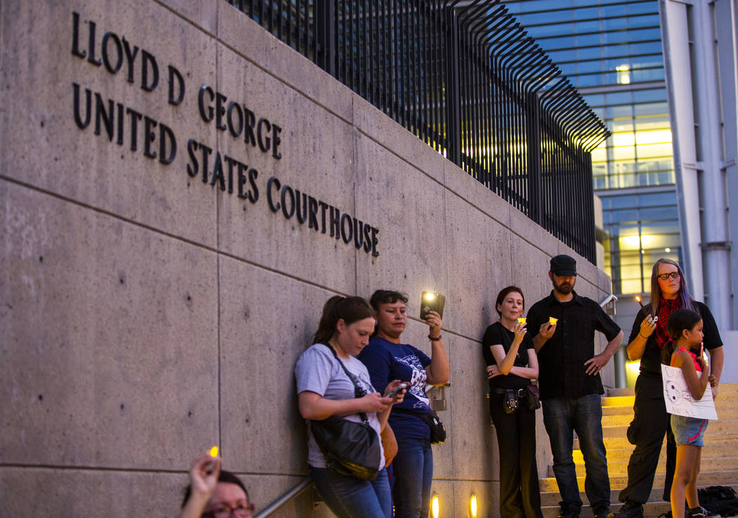 Advocates, activists and impacted persons hold lit candles and yell protest chants during Light ...