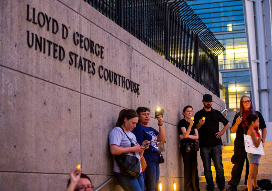 Advocates, activists and impacted persons hold lit candles and yell protest chants during Light ...