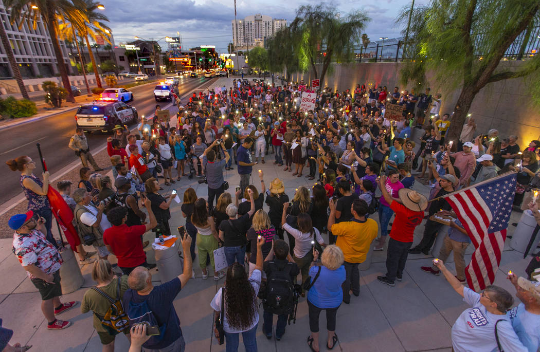 Advocates, activists and impacted persons hold lit candles and yell protest chants during Light ...