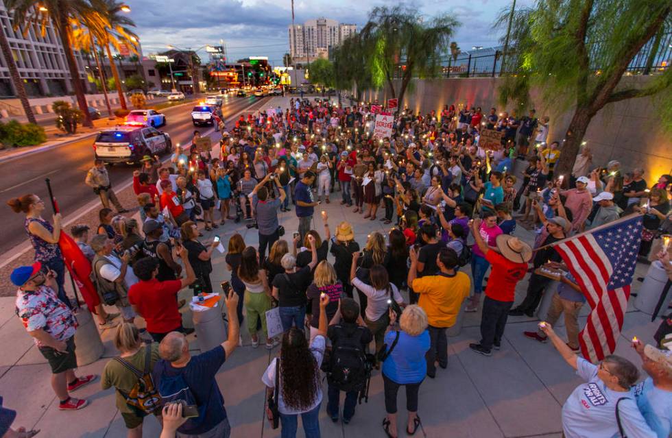 Advocates, activists and impacted persons hold lit candles and yell protest chants during Light ...