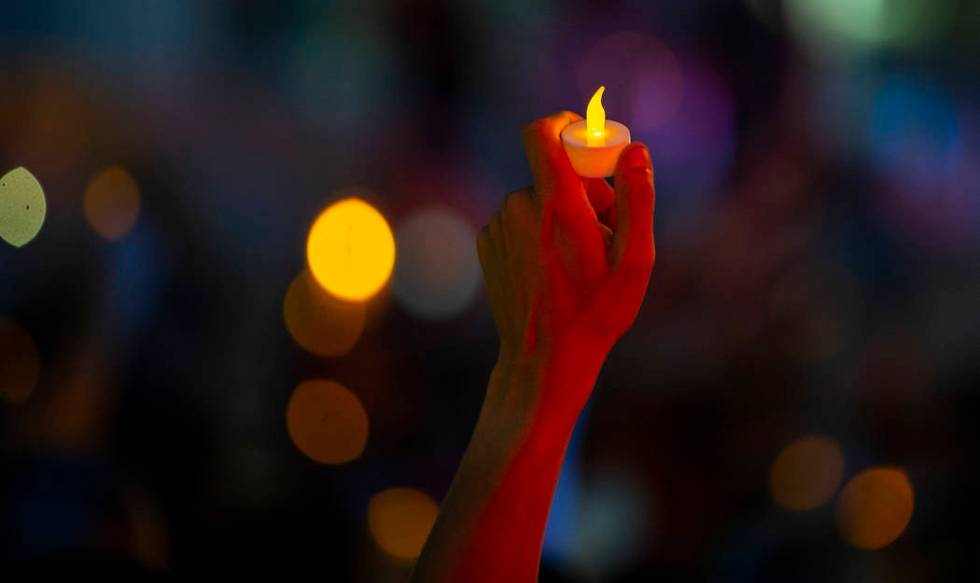 Advocates, activists and impacted persons hold lit candles and yell protest chants during Light ...