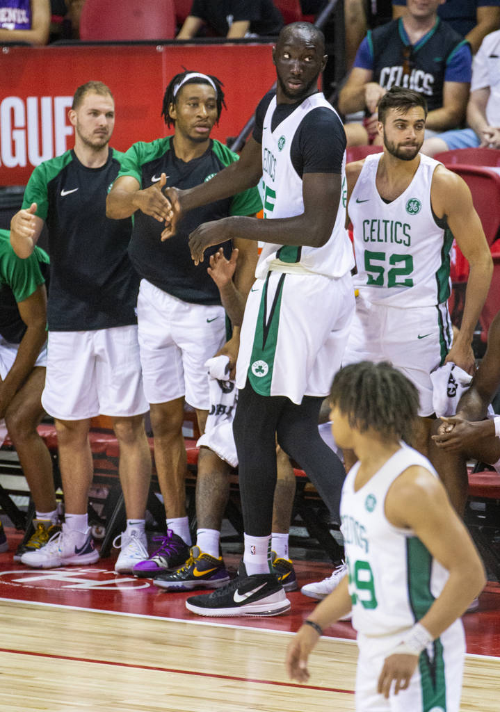 Boston Celtics center Tacko Fall, center, is congratulated by teammates after good play versus ...