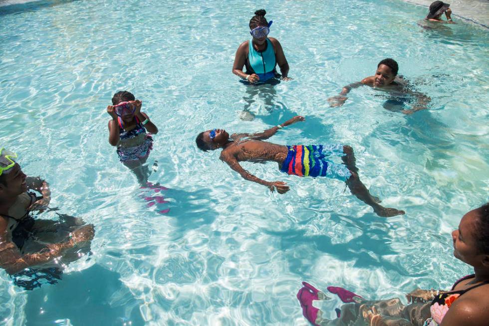 Dillon Hanger, 12, floats in a pool surrounded by his family Tamia Boston, 17, from left, Makay ...