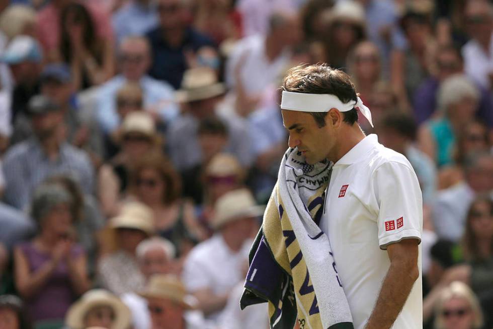 Switzerland's Roger Federer wipes his face after losing a set to Serbia's Novak Djokovic during ...