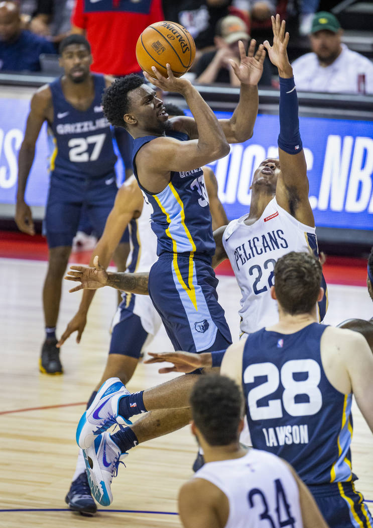 Memphis Grizzlies guard Keenan Evans, left, elevates to the basket over New Orleans Pelicans gu ...