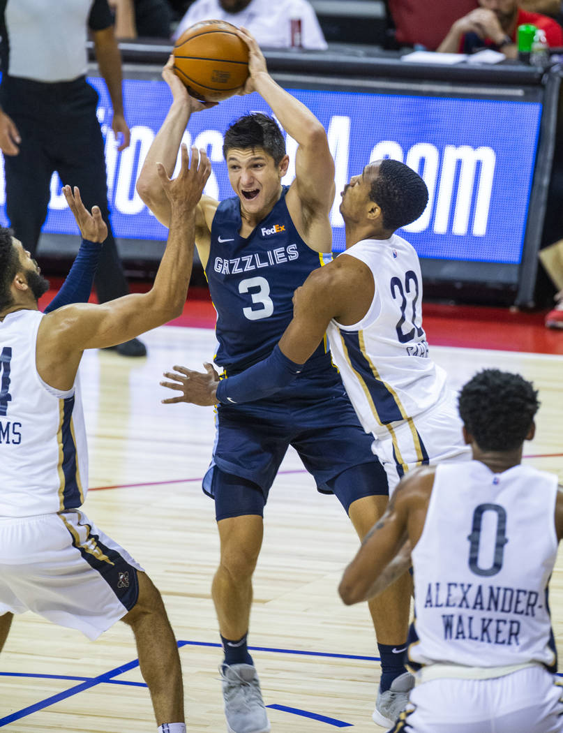 Memphis Grizzlies guard Grayson Allen, center, looks to pass over New Orleans Pelicans guard To ...