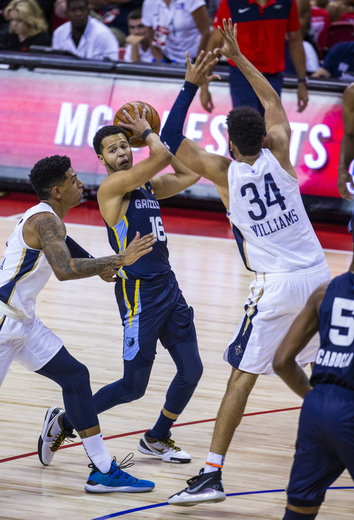 Memphis Grizzlies guard Tyler Harvey, center, looks to pass from between New Orleans Pelicans f ...