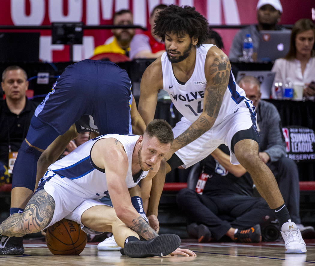 Minnesota Timberwolves forward Mitch Creek, below, sits on the ball after scrambling for it wit ...