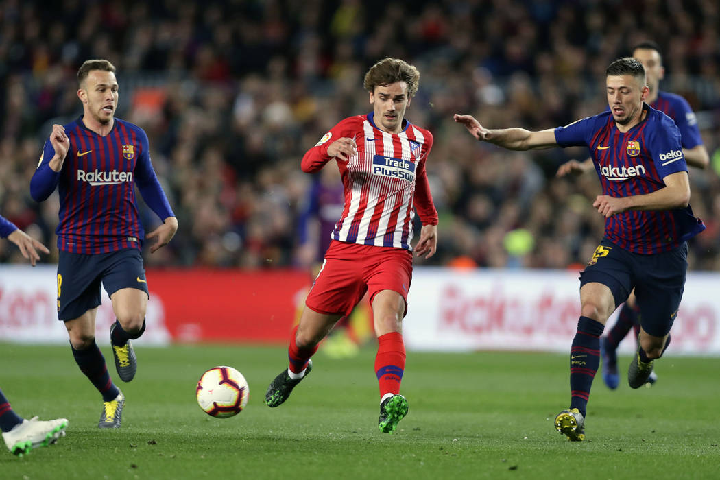 FILE - In this April 6, 2019, file photo, Atletico forward Antoine Griezmann, center, vies for ...