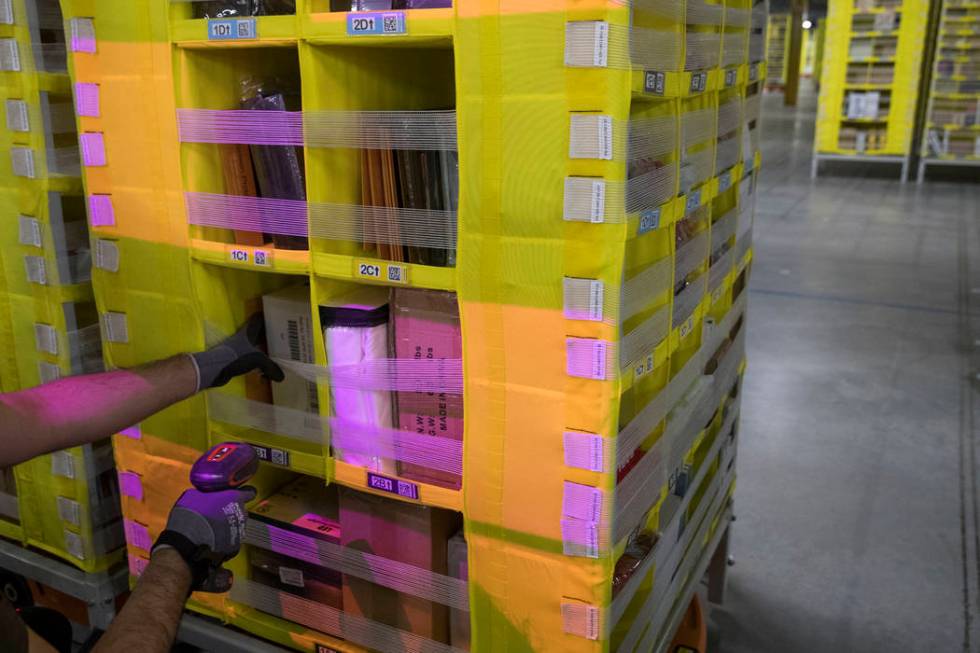 A Dec. 5, 2018, file photo shows Amazon Stower Leo Esparragoza using colored light to help sort ...