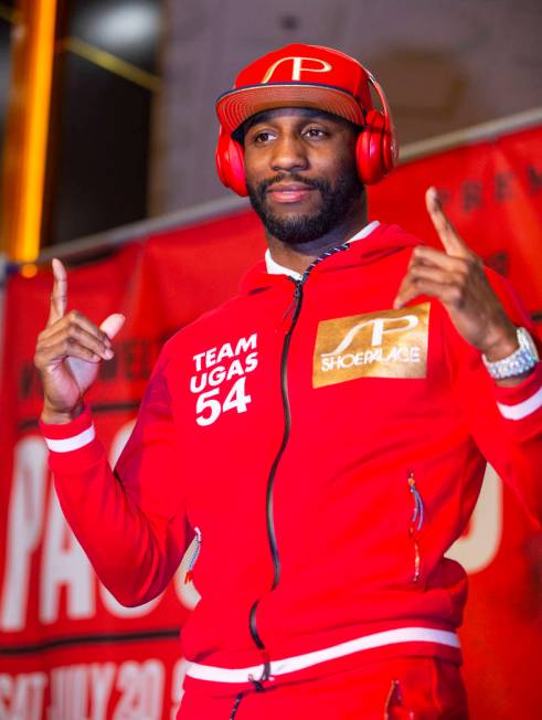 Boxer Yordenis Ugas points up to the crowd from the stage during fighter grand arrivals at the ...