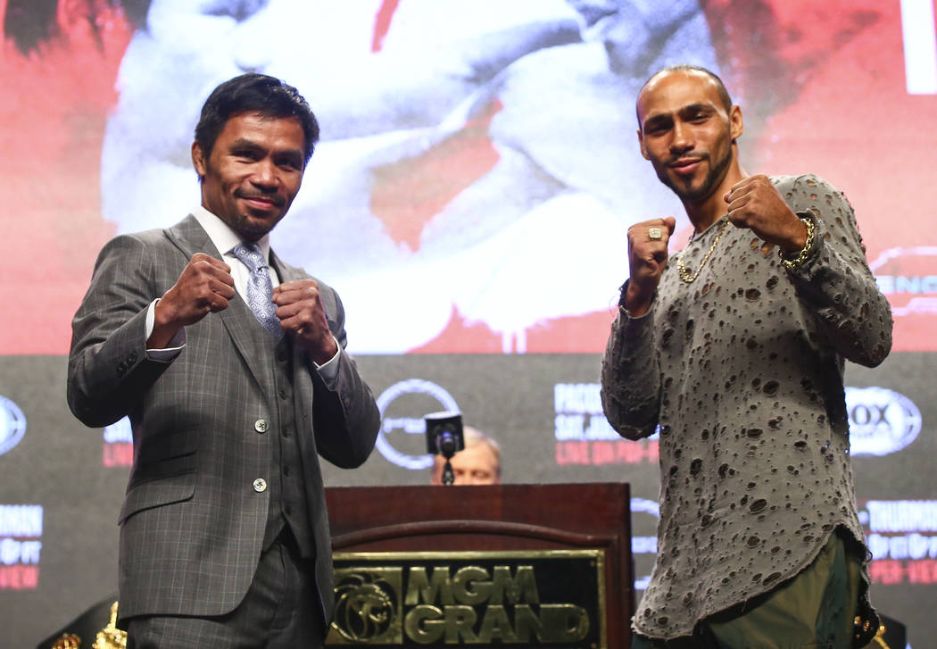 Manny Pacquiao, left, and Keith Thurman pose for pictures during a press conference ahead of th ...